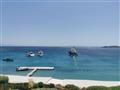 Pohľad na nádherné more a zátoku Ornos Bay z hotela Santa Marina. Tyrkysovo-modrá priezračná chladiv