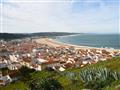 Mesto Nazaré s domami a pláž v Portugalsku.