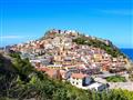Domy na kopci v Castelsardo a more v pozadí na Sardínii.